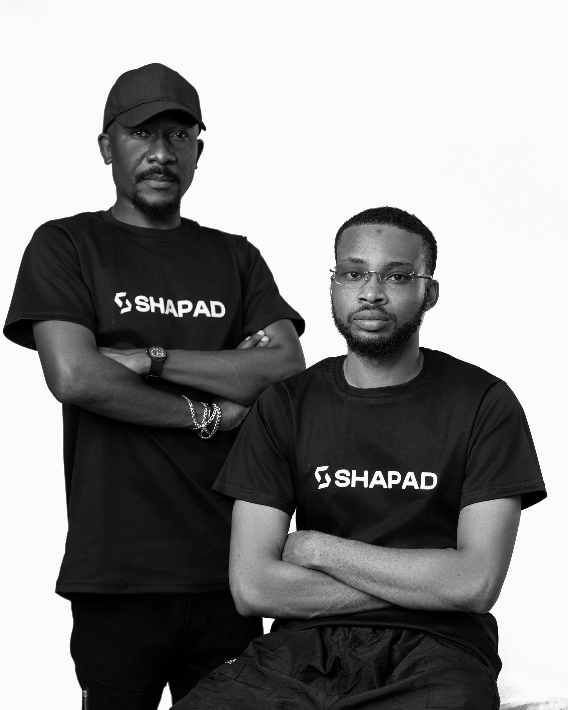 Two members of the Shapad team in black SHAPAD t-shirts with arms crossed, black-and-white studio portrait